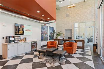 A black and white checkered floor in a room with orange chairs and a white counter.